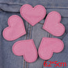 Five pink glitter heart star iron-on patches arranged in a circle on denim fabric