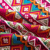 Close-up of vibrant bohemian printed linen fabric featuring geometric patterns in pink, orange, green, and white.