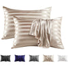 Set of elegant satin and silk striped pillow covers in beige and silver tones.