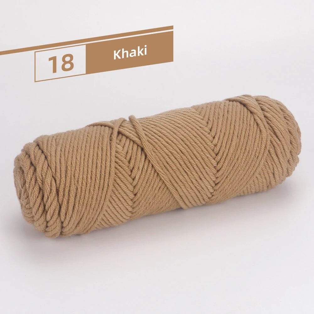 A skein of khaki colored premium worsted cotton yarn is shown lying on a white surface.