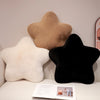 A collection of star-shaped decorative throw pillows in beige, white, and black.