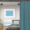 A teal curtain track room divider with fabric panels hanging from the ceiling in a bright room.