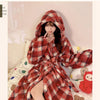 A woman wearing a red and brown plaid flannel kimono robe indoors.