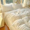 A white lace seersucker duvet cover set displayed on a bed with sheer curtains and natural light.