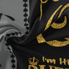 Black fabric with gold leaf patterns resembling a royal crown and text