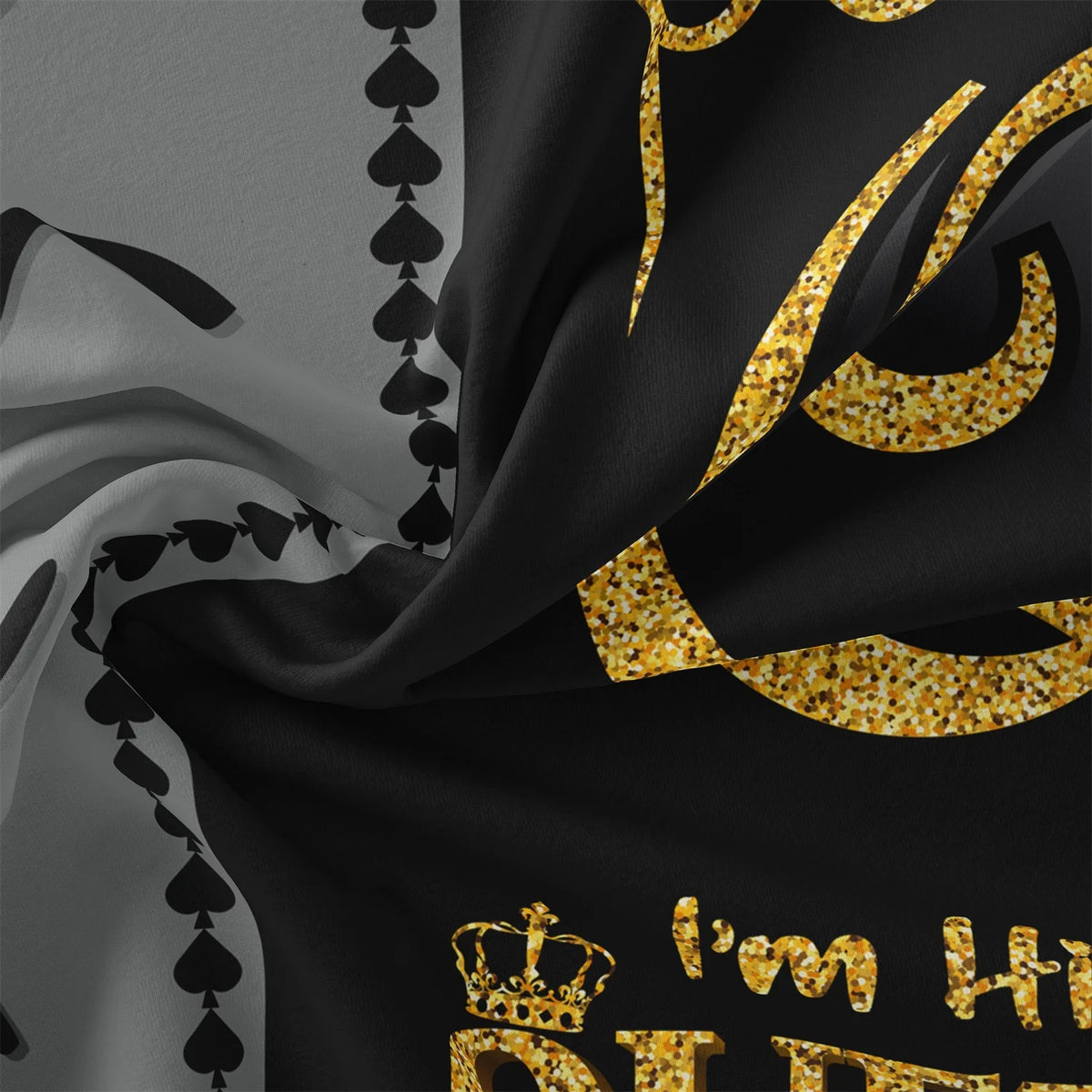 Black fabric with gold leaf patterns resembling a royal crown and text