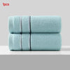 A stack of light blue, textured face towels with black stripes.