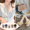 A close-up of pearl button pins in various colors and finishes for DIY decoration.
