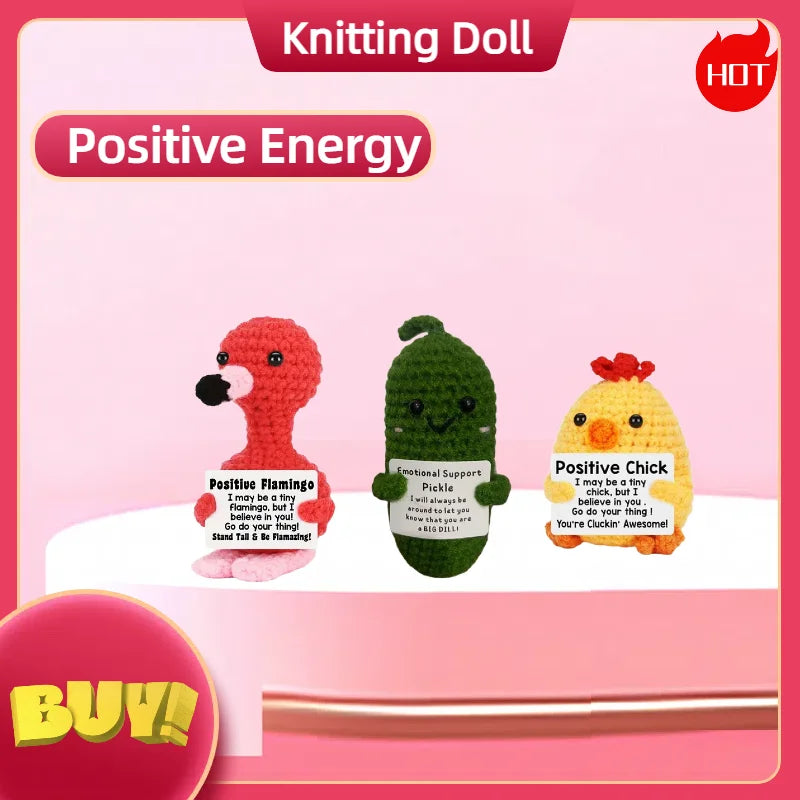 A knitted doll named Positive Energy featuring a flamingo, a green creature, and a yellow chick.