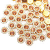 Golden and rose gold crystal rhinestone sew-on buttons scattered on a white background