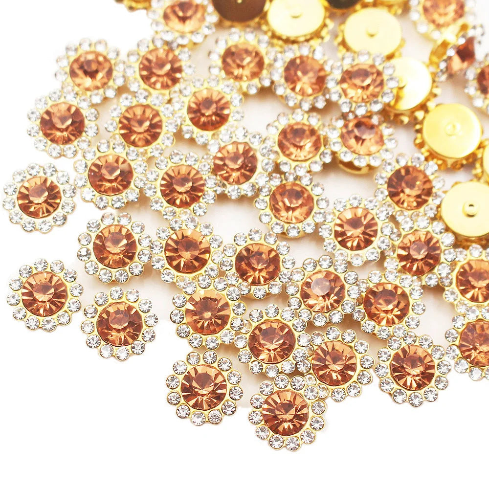 Golden and rose gold crystal rhinestone sew-on buttons scattered on a white background