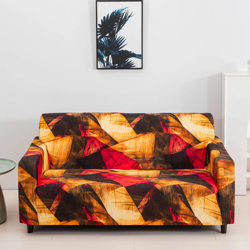 A modern sofa covered in a vibrant, abstract floral pattern featuring warm tones of orange, yellow, red, and black.