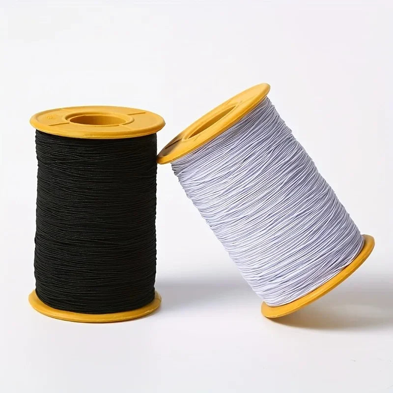 A spool of black elastic sewing thread on a yellow spindle.