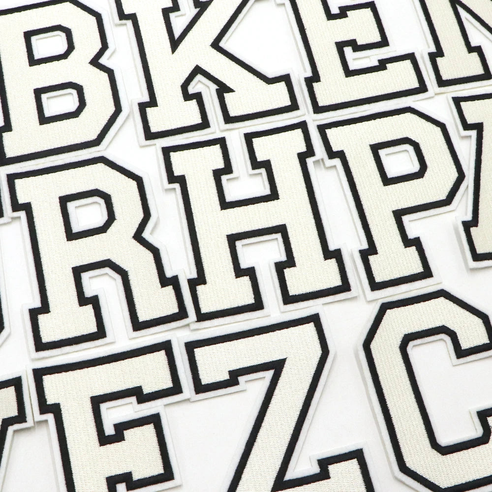 A collection of black and white letter patches for clothing decoration.