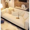 A cream colored plush anti-slip sofa seat cushion cover displayed on a modern sofa with light beige throw pillows.