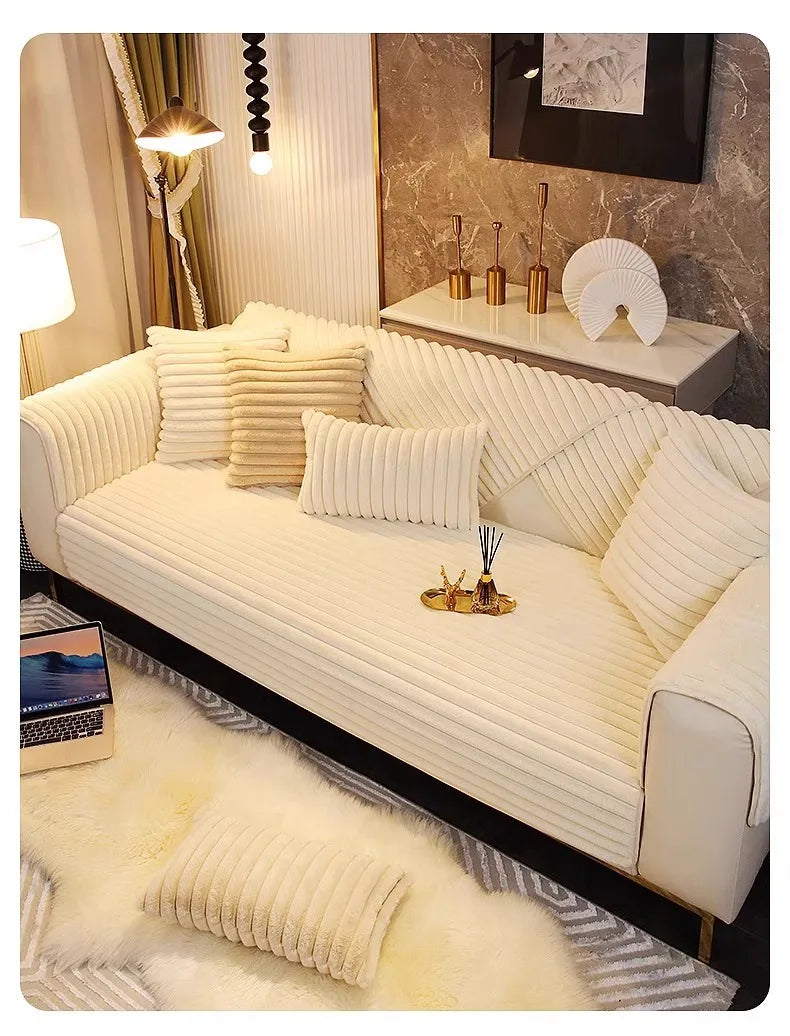 A cream colored plush anti-slip sofa seat cushion cover displayed on a modern sofa with light beige throw pillows.