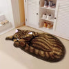 A brown and gold cartoon cat plush rug lying on a light floor next to a white cabinet with shoes.