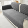 Gray geometric quilted sofa cushion covers on a light-colored sofa.