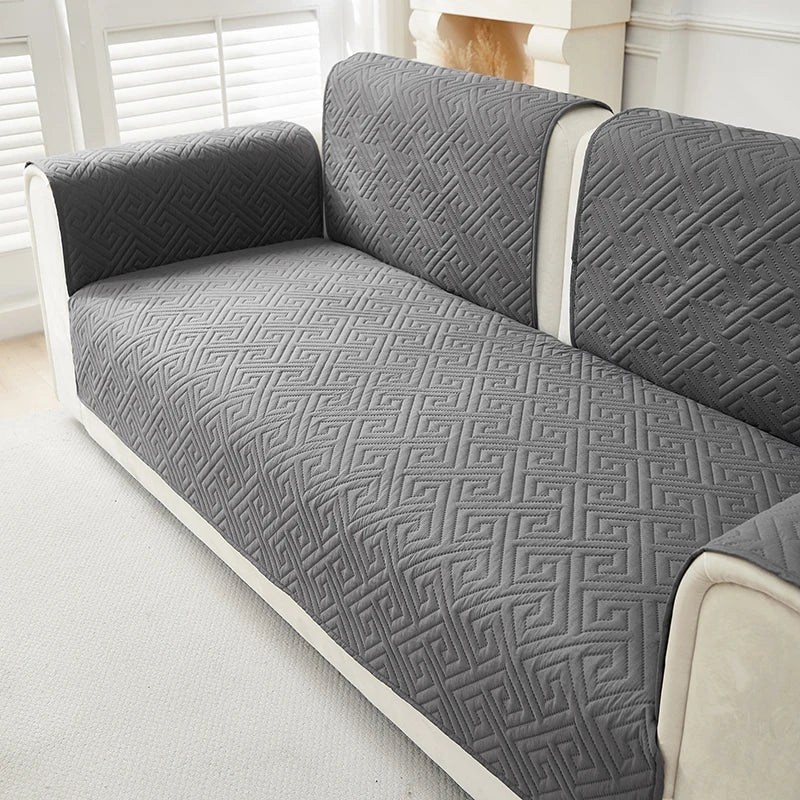 Gray geometric quilted sofa cushion covers on a light-colored sofa.
