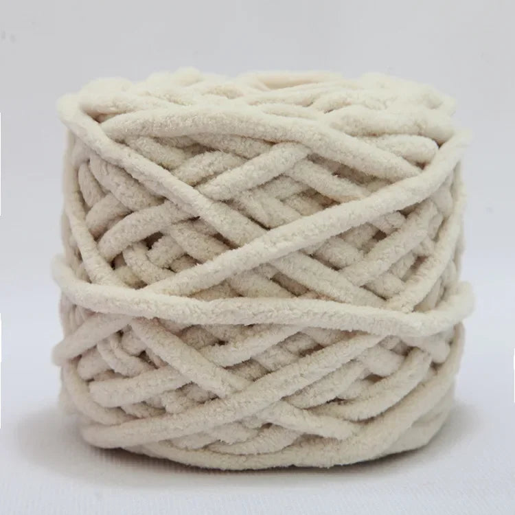 A ball of soft, cream-colored chenille knitting yarn coiled for hand crafting.