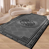 A modern geometric soft area rug with gray and black patterns in a living room setting.