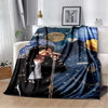 A dark blue and black printed flannel blanket featuring a musician playing an electric guitar.