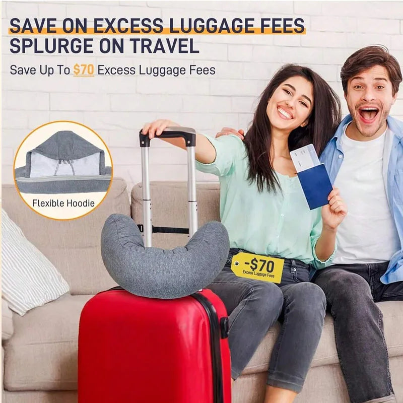 A woman is sitting on a couch with a red rolling suitcase and a travel pillow, smiling while holding a document.