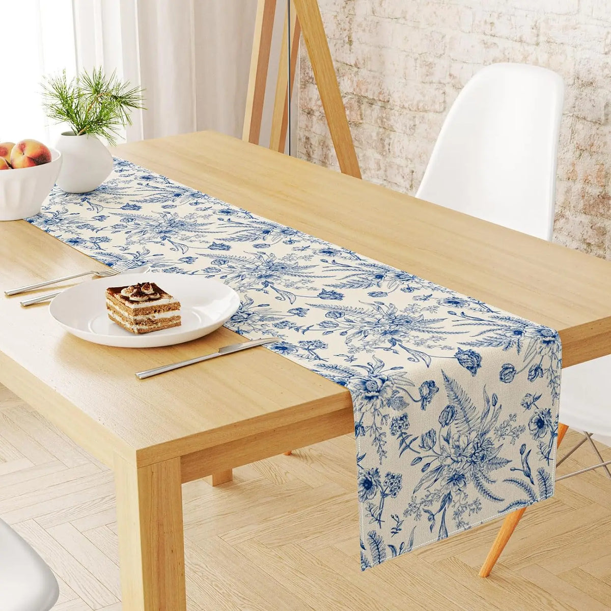 Blue and white porcelain floral linen table runner displayed on a wooden table.