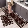 A dark brown diamond print non-slip kitchen rug set featuring white borders placed on a light wood floor.