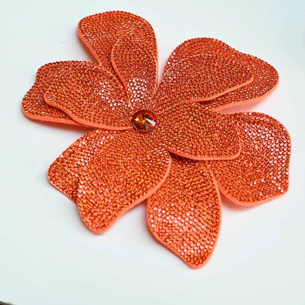 Orange rhinestone flower applique patches arranged in a starburst pattern.