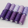 A set of ten spools of purple and lavender polyester sewing thread stacked in a row.
