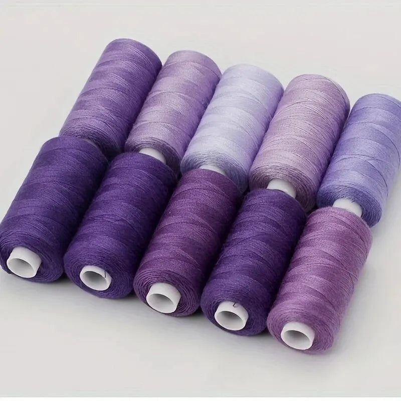A set of ten spools of purple and lavender polyester sewing thread stacked in a row.