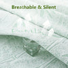 A close-up of a white bamboo fiber fitted sheet draped over a green surface, with a glass resting on the fabric.