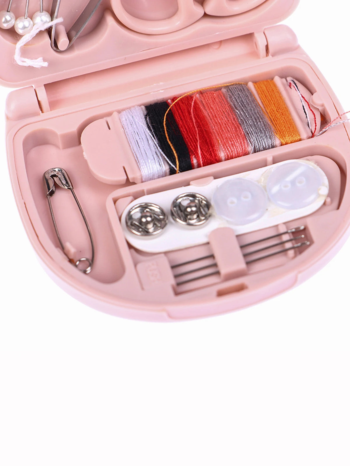 A pink portable DIY sewing box containing colored threads, pins, and sewing tools for home crafts.