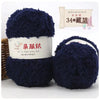 A ball of dark blue fuzzy yarn labeled as Plant Made Soft Coral Velvet Yarn for crafting.