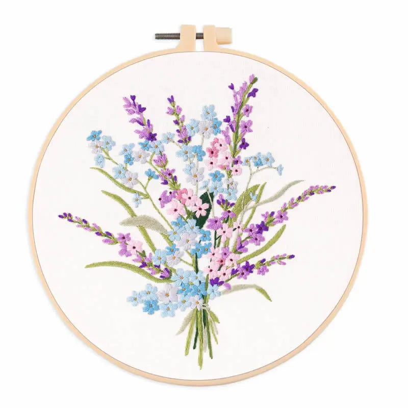 A circular embroidery hoop displaying a bouquet of purple, blue, and pink wildflowers.
