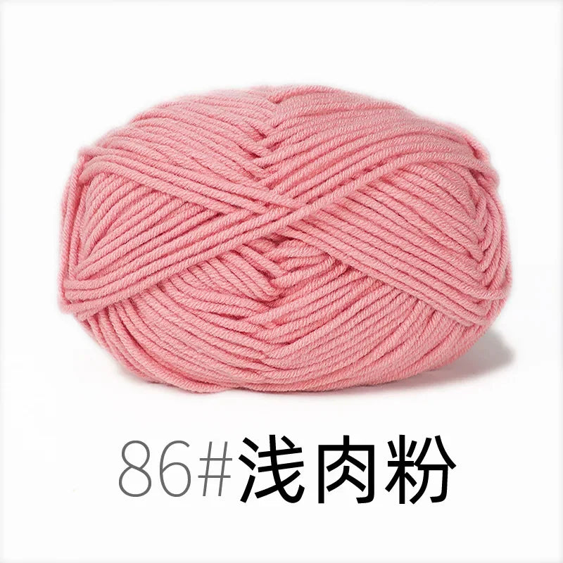 A ball of pink organic cotton 4ply knitting yarn with a crisscross pattern.