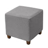 Gray jacquard stretch ottoman slipcover with a diamond pattern