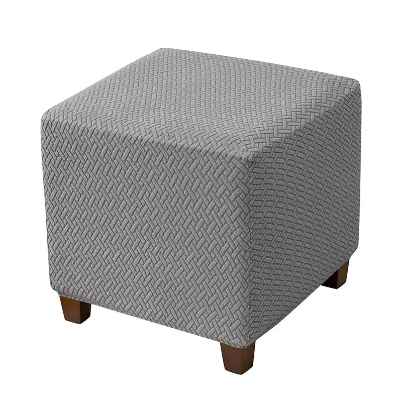 Gray jacquard stretch ottoman slipcover with a diamond pattern