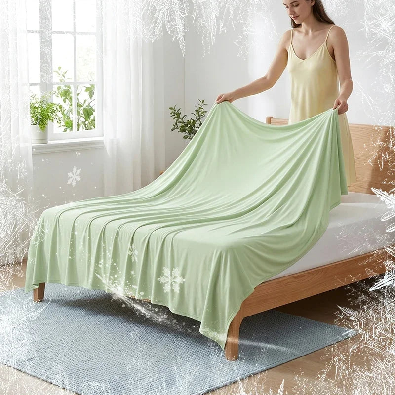 A light green ice silk cooling blanket is draped over a wooden bed, with frost effects visible on the fabric and surrounding 