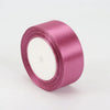 A roll of 4cm satin ribbon in a dusty rose color for crafts and gift wrapping.