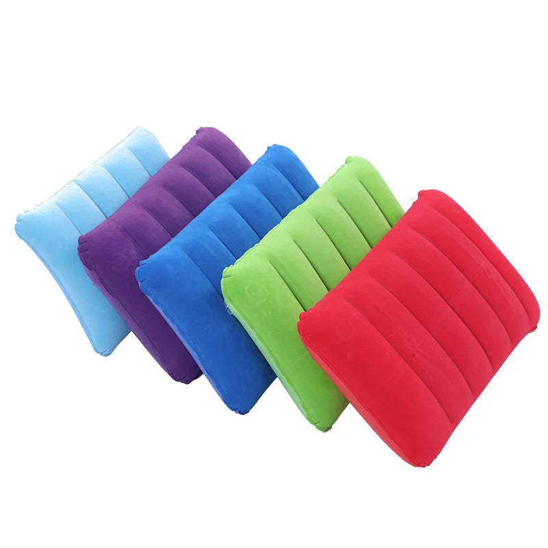 A collection of colorful portable inflatable travel pillows in shades of blue, purple, green, and red.