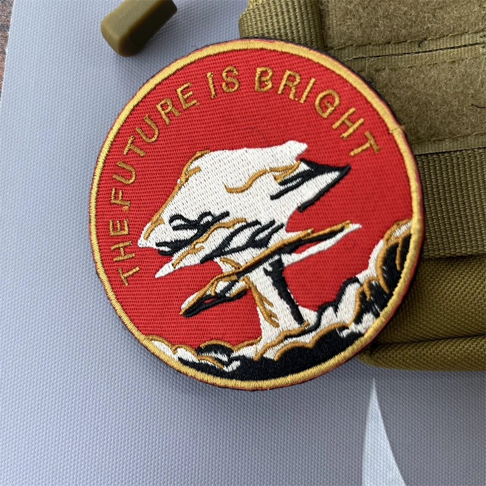 Red embroidered patch featuring a white mushroom cloud design and the text FUTURE IS BRIGHT on a khaki fabric background.