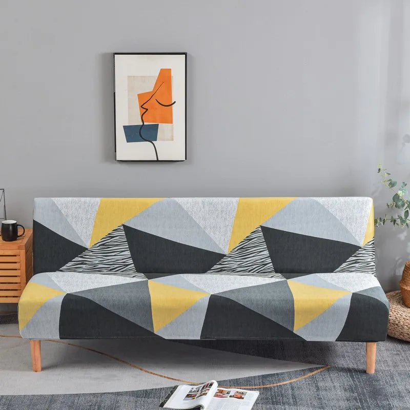 A modern sofa with geometric print spandex slipcovers featuring gray, yellow, and black triangles.