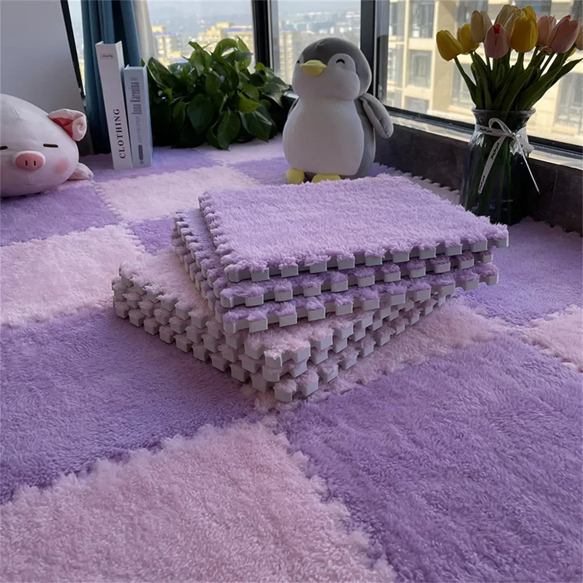 A purple plush interlocking puzzle rug mat is displayed on a purple rug with a stuffed penguin and flowers in the background.