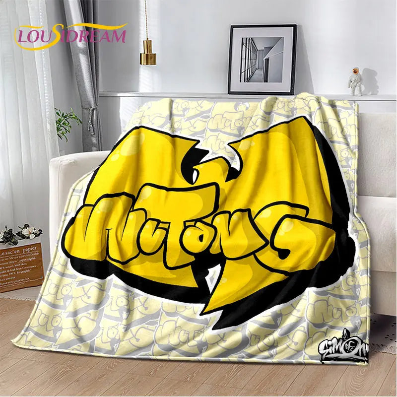 A yellow and black graphic design blanket featuring a stylized cat head on a light patterned background.