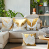 A sofa decorated with golden white wing-shaped decorative throw pillows.