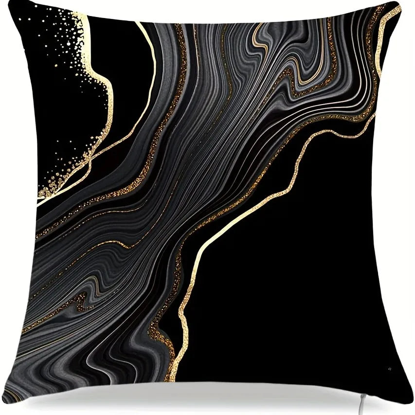 Black pillow cover with swirling gold and black marble patterns and scattered gold dots