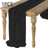 A black semi-sheer gauze table runner draped over a wooden table.