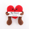 A handmade plush doll shaped like a red heart with brown legs and a white tag that reads My Heart